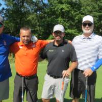 Four men posing on gold course